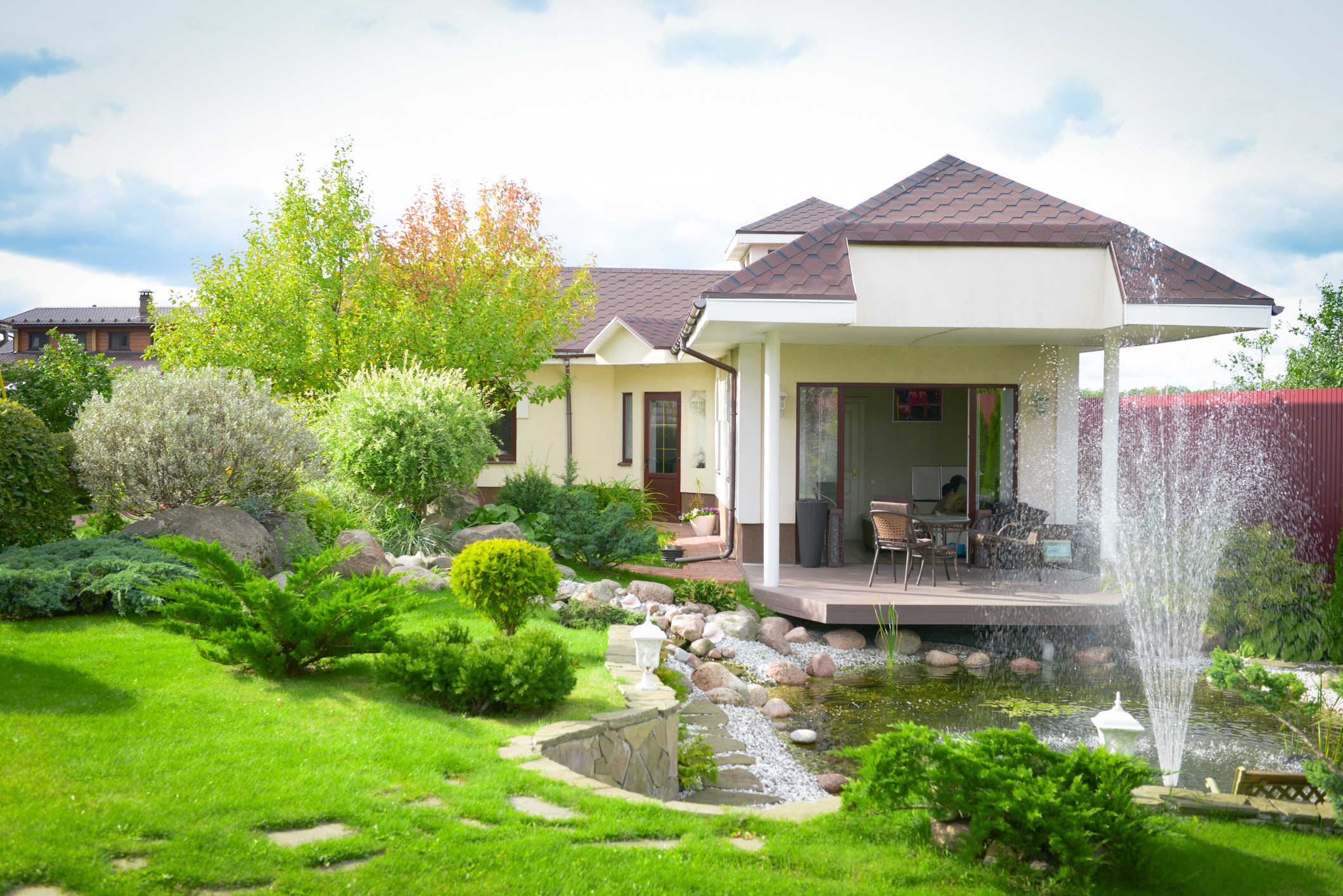 A beautiful outdoor home garden including a fountain shows the value of a well-kept outdoor space.